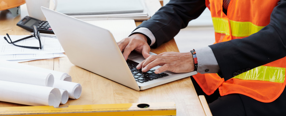 storage/images/posts//unrecognizable-man-neon-safety-vest-business-suit-sitting-desk-using-laptop1_1717157075.jpg